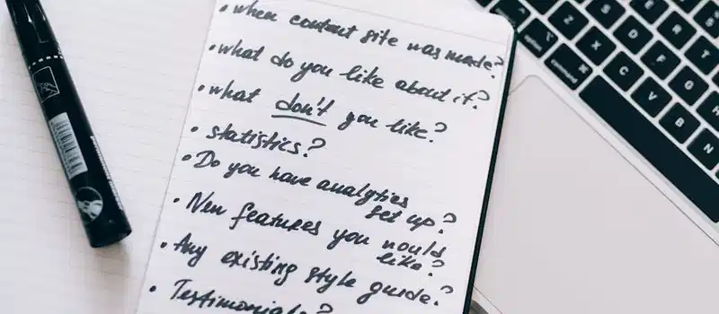 Close-up of a notebook with handwritten notes next to a laptop, ideal for business or educational content.