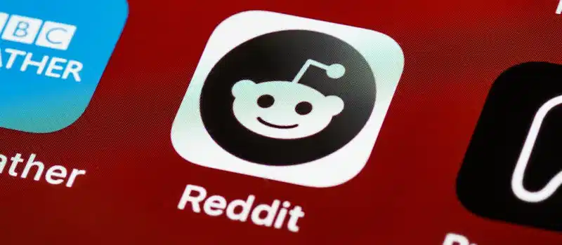 Detailed view of the Reddit app icon on a smartphone screen displaying popular applications.