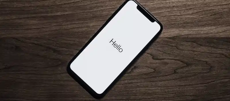 A smartphone displaying 'Hello' on a wooden surface, showcasing modern technology.