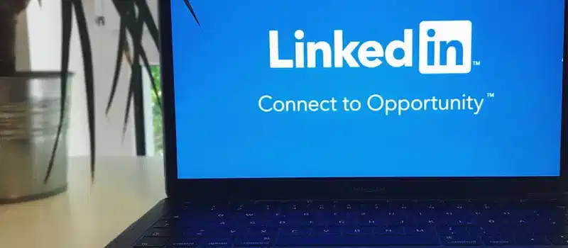 A laptop screen displaying the LinkedIn logo with the text 'Connect to Opportunity'.